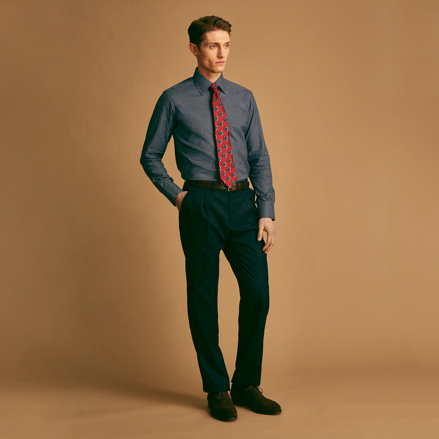 View 3 of product A rolled-up Red Shadow Spot Printed Silk Tie by Turnbull & Asser, showcasing large navy blue and white circular motifs, displayed on a plain white background.