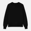 View 3 of product The Turnbull & Asser Black Crew Neck Cashmere Jumper is shown laid flat on a white background, featuring ribbed cuffs and hem with a small white label inside the collar.