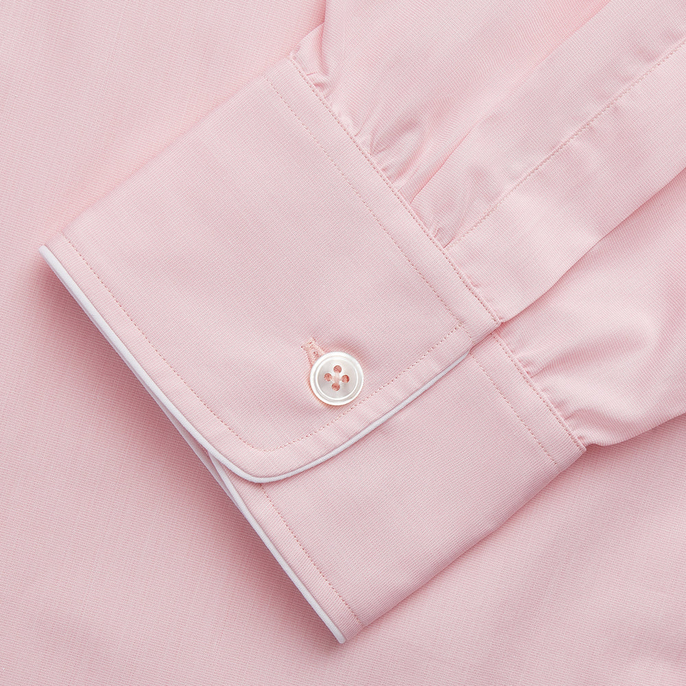 The Turnbull & Asser Pink Piped End-On-End Cotton Nightshirt features long sleeves, a pointed collar, button-down front, chest pocket, and a curved high-low hem for timeless, relaxed style.