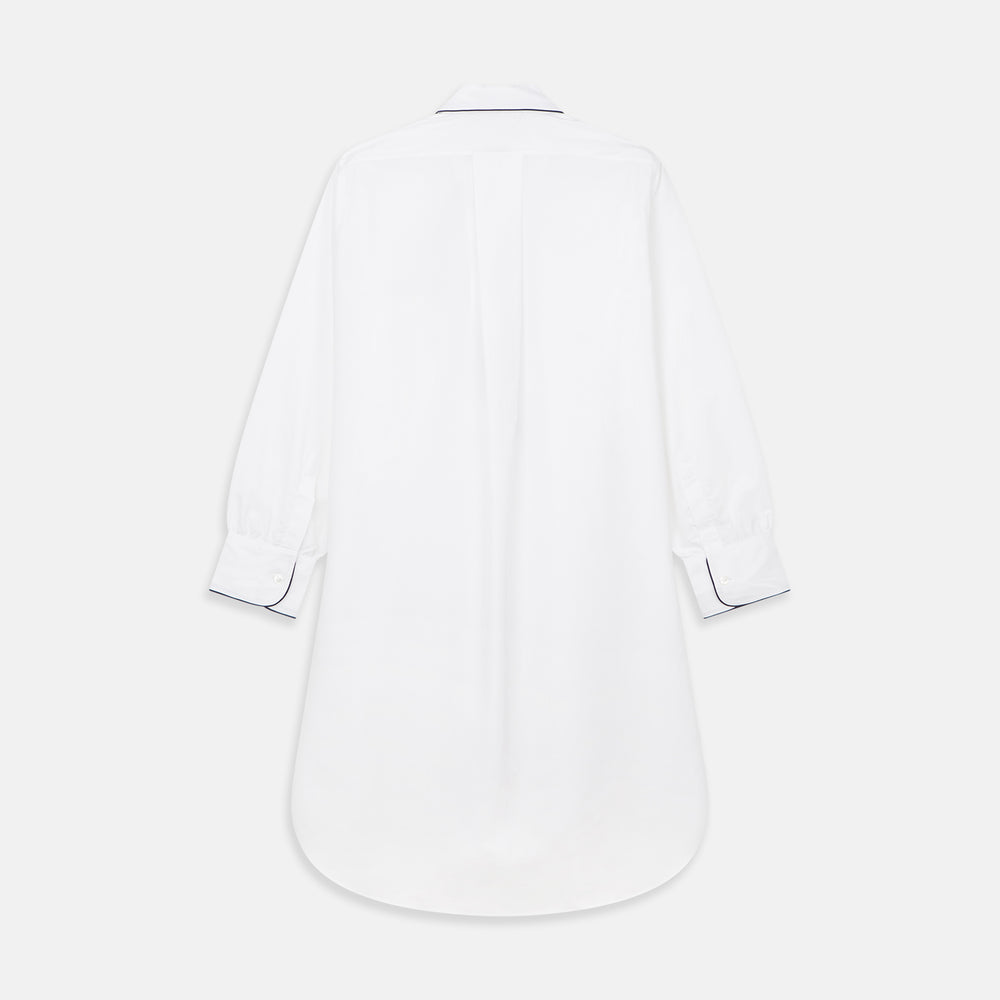 The Turnbull & Asser White Piped Cotton Nightshirt features black piping on the collar, chest pocket, and cuffs, plus a curved hem and loose-fitting sleeves gathered at the wrists for a classic look.