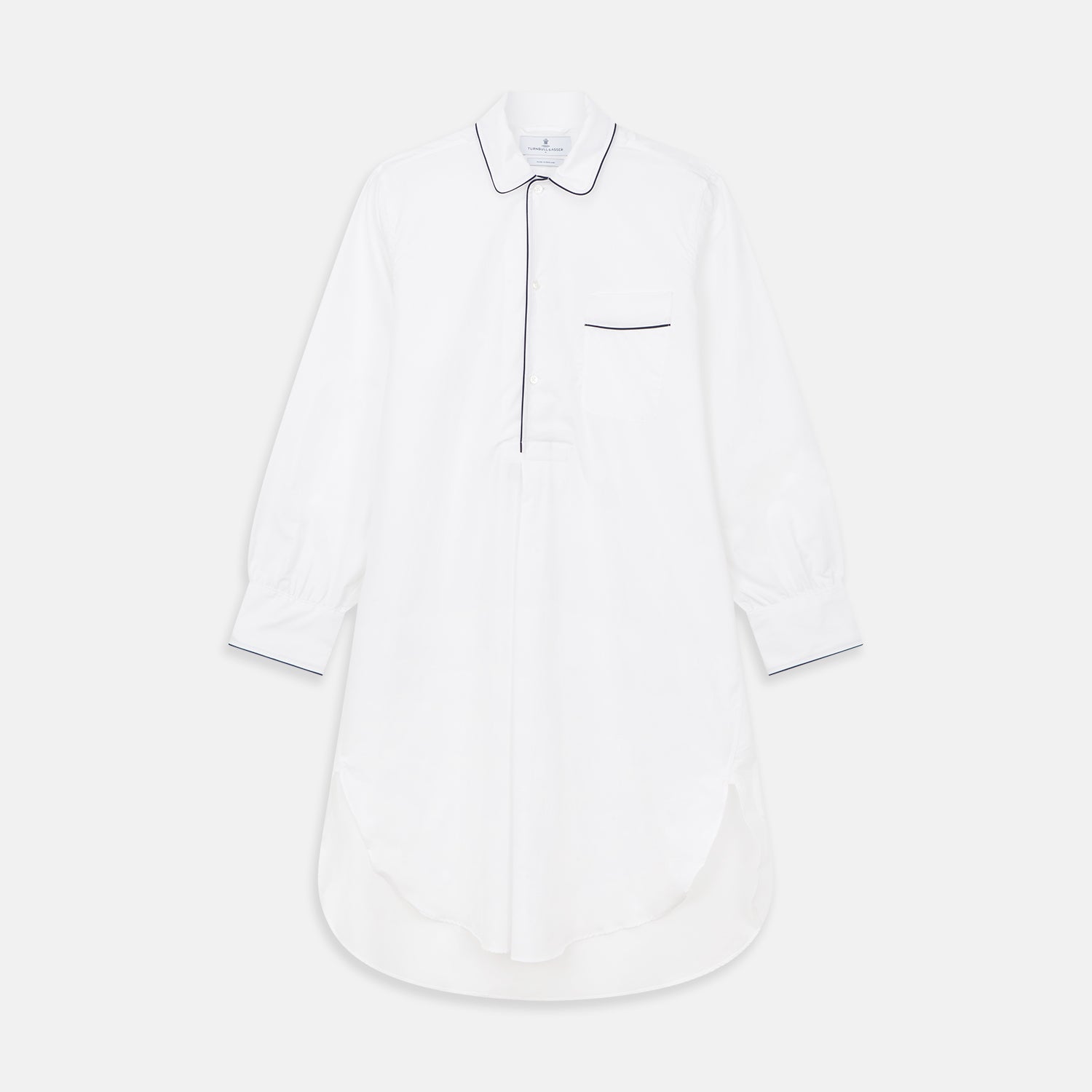 View 1 of product The Turnbull & Asser White Piped Cotton Nightshirt features black piping on the collar, chest pocket, and cuffs, plus a curved hem and loose-fitting sleeves gathered at the wrists for a classic look.