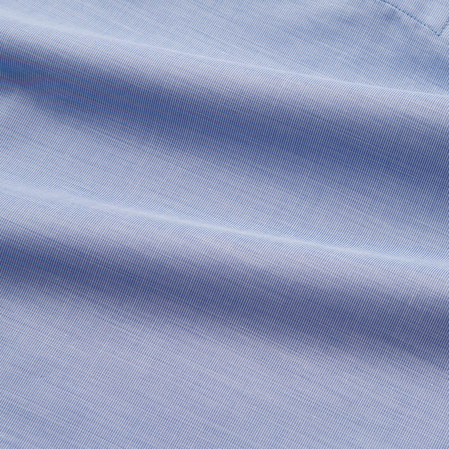 View 4 of product The Blue Piped End-on-End Cotton Nightshirt by Turnbull & Asser features light blue cotton, red piped accents, a chest pocket, high-low hem, and half-button placket—luxurious nightwear inspired by classic nightshirt style.