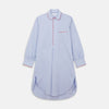 View 1 of product The Blue Piped End-on-End Cotton Nightshirt by Turnbull & Asser features light blue cotton, red piped accents, a chest pocket, high-low hem, and half-button placket—luxurious nightwear inspired by classic nightshirt style.