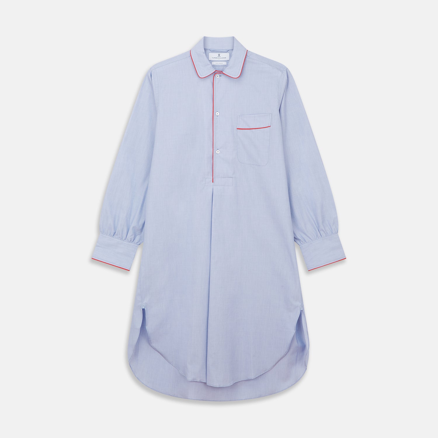 View 1 of product The Blue Piped End-on-End Cotton Nightshirt by Turnbull & Asser features light blue cotton, red piped accents, a chest pocket, high-low hem, and half-button placket—luxurious nightwear inspired by classic nightshirt style.