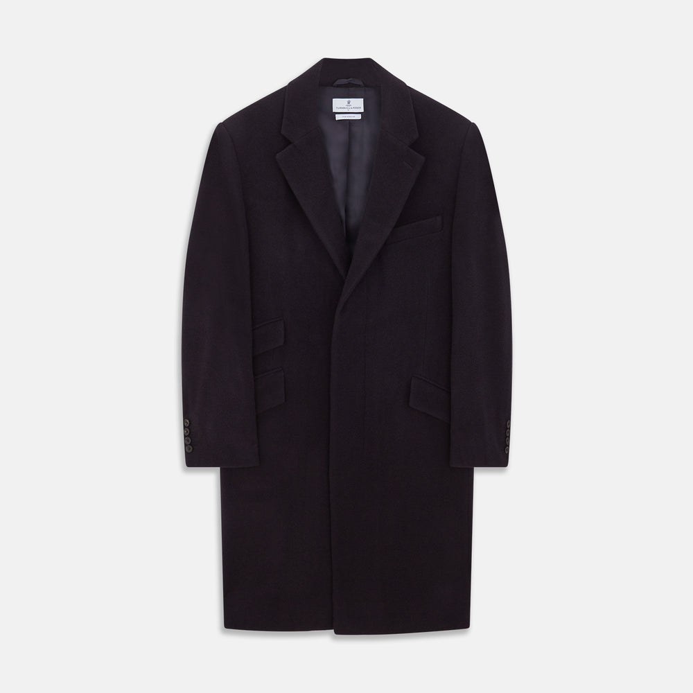 The Turnbull & Asser Navy Cashmere Joseph Overcoat features notched lapels, three front pockets, buttoned cuffs, and a hidden button closure—an essential men’s outerwear piece shown against a plain white background.