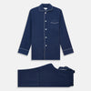 View 2 of product The Turnbull & Asser Navy Piped Silk Pyjama Set features a long-sleeve button-up top with a chest pocket and matching drawstring pants, laid flat on a white background for a luxurious look.