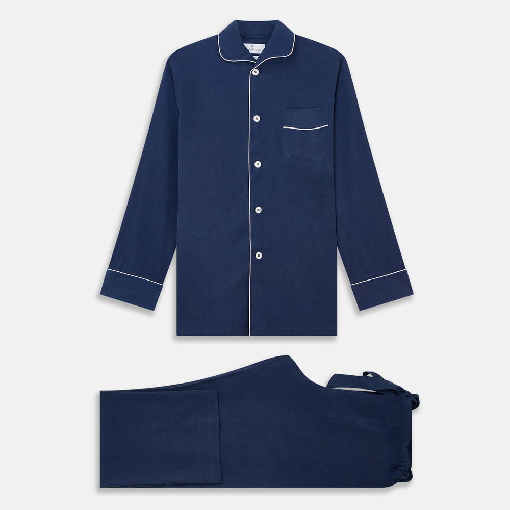 The Turnbull & Asser Navy Piped Silk Pyjama Set features a long-sleeve button-up top with a chest pocket and matching drawstring pants, laid flat on a white background for a luxurious look.