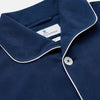 View 3 of product The Turnbull & Asser Navy Piped Silk Pyjama Set features a long-sleeve button-up top with a chest pocket and matching drawstring pants, laid flat on a white background for a luxurious look.