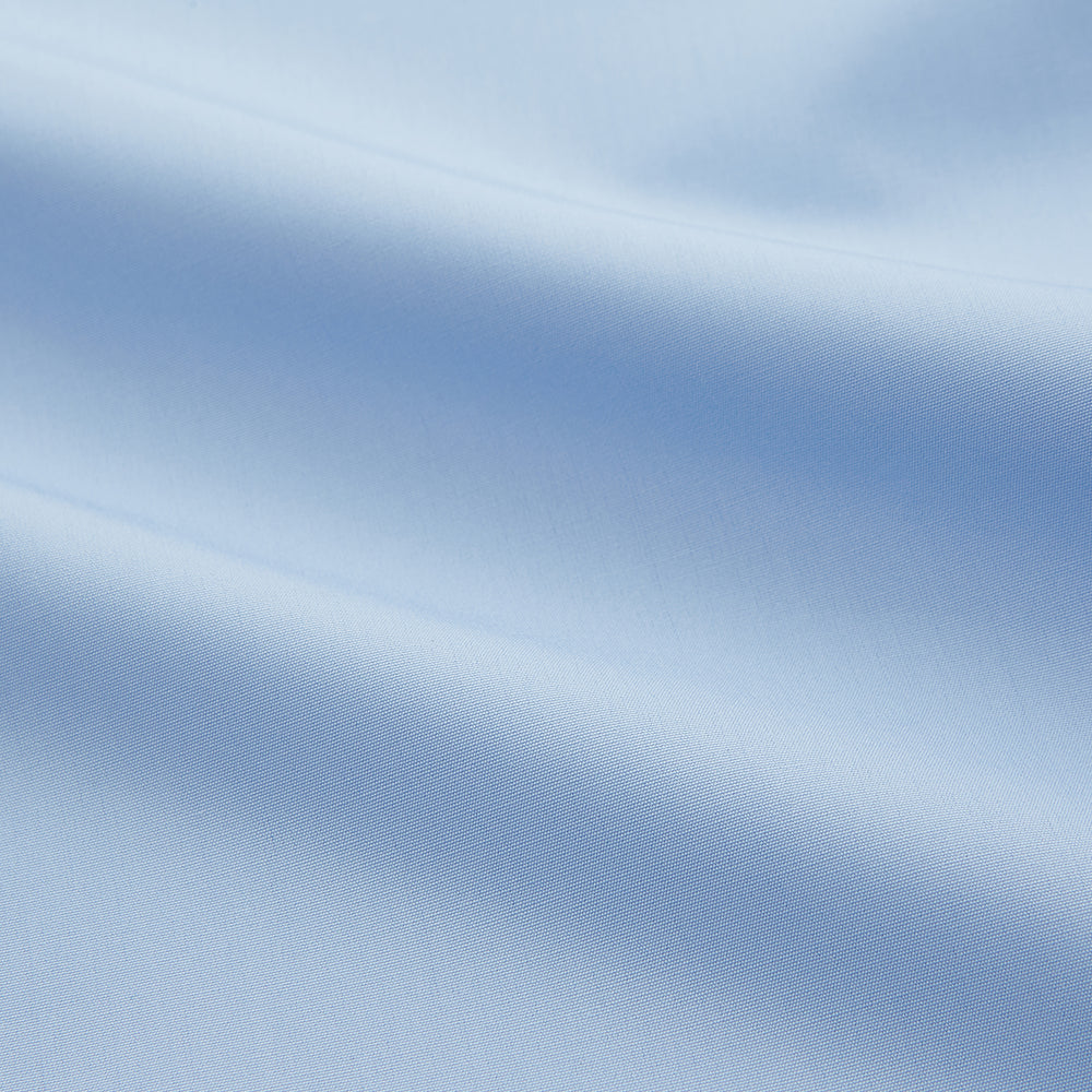 The Turnbull & Asser Pale Blue Organic Cotton Regular Fit Mayfair Shirt features long sleeves, a pointed collar, white buttons, and buttoned cuffs, shown laid flat on a white background.