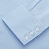 View 3 of product The Turnbull & Asser Pale Blue Organic Cotton Regular Fit Mayfair Shirt features long sleeves, a pointed collar, white buttons, and buttoned cuffs, shown laid flat on a white background.