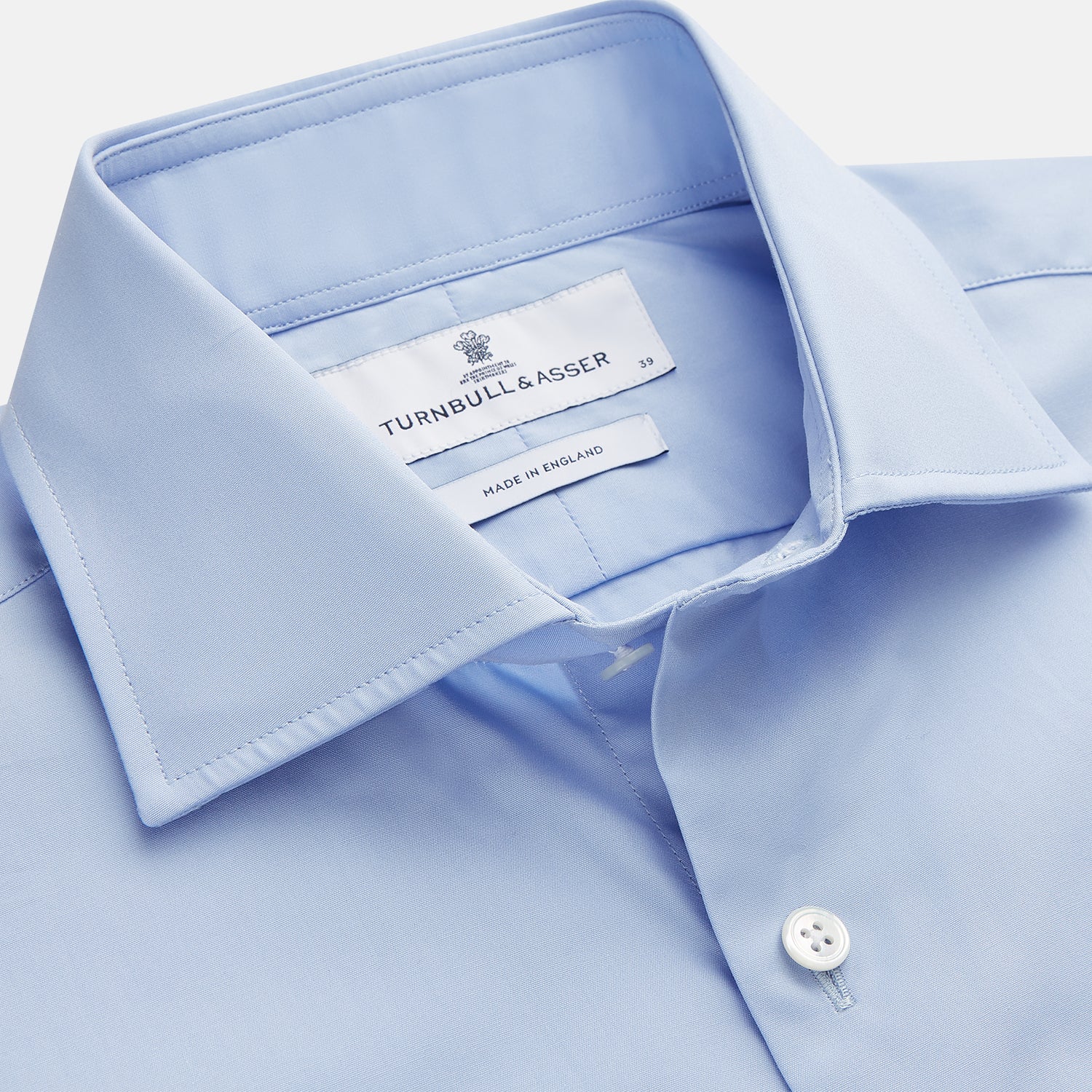 View 2 of product The Turnbull & Asser Tailored Fit Blue Cotton Shirt features a Kent collar and double cuffs, laid flat on a white background—ideal for pairing with a navy suit or any smart look.