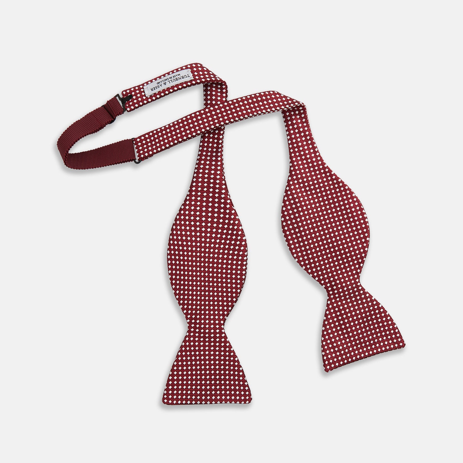 View 2 of product The Turnbull & Asser Burgundy and White Diamond Silk Bow Tie features a textured pattern of small white diamonds, ideal for white shirts, presented on a plain white background.