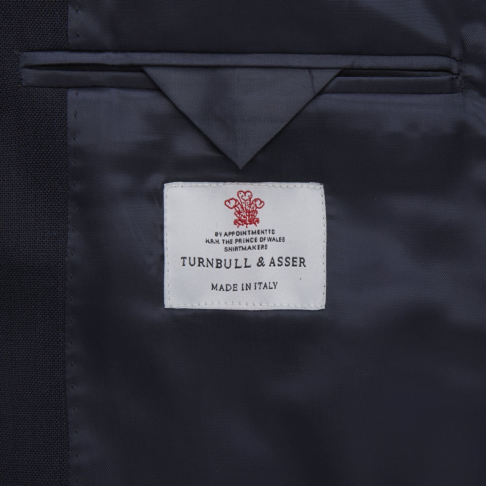 View 2 of product The Turnbull & Asser Navy Lightweight Wool Hopsack Traveller Jacket features a notched lapel, three front buttons, and four flap pockets—two on the chest and two at the waist—all displayed on a plain white background.
