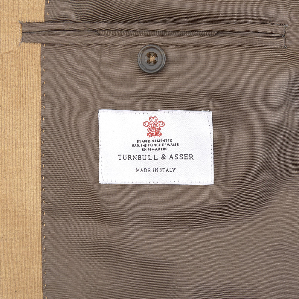 The Turnbull & Asser Camel Cotton Cashmere Corduroy Jacket from the Autumn/Winter collection features notch lapels, a single-breasted button closure, and multiple front pockets. Shown against a plain white background.