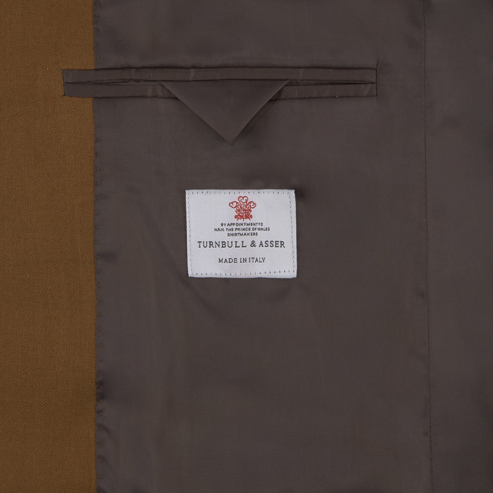The Turnbull & Asser Tobacco Plainweave Cashmere Jacket is a single-breasted brown summer jacket with two buttons, notch lapels, and flap pockets, tailored in Italy and shown on a plain white background.