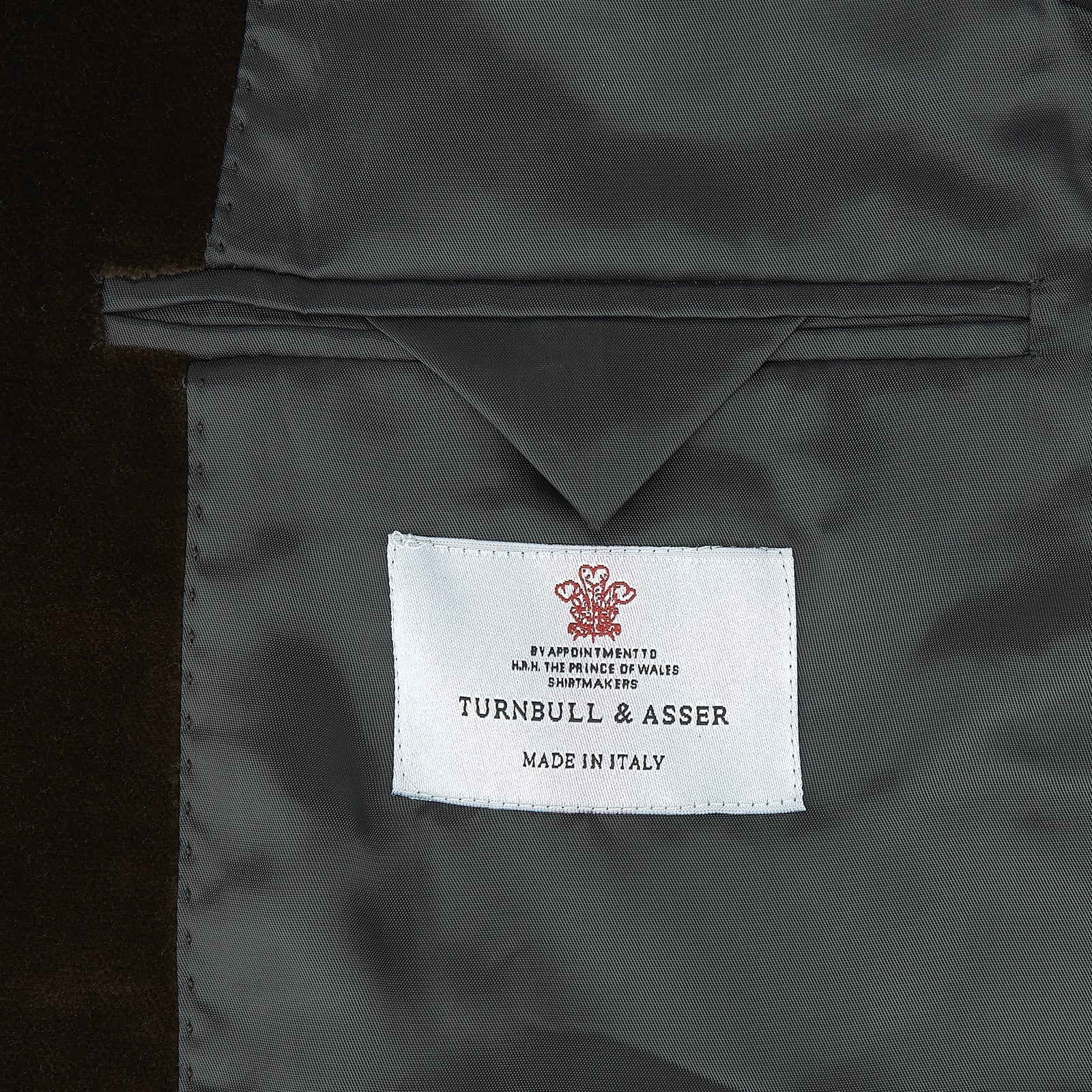 View 3 of product The Turnbull & Asser Brown Velvet Jacket for men features a notched lapel, two buttons, flap pockets, and a chest pocket, shown against a plain white background.