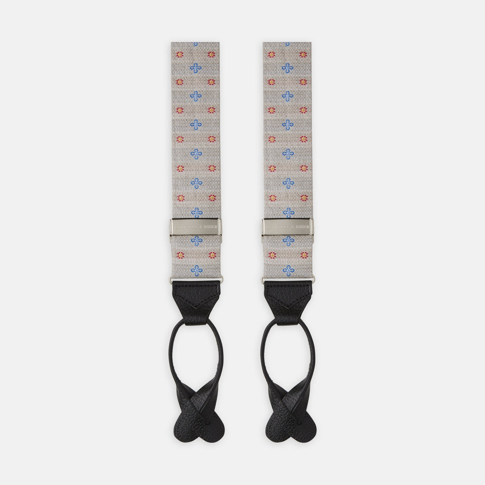 Turnbull & Asser’s Dove Grey Floral Silk and Linen Adjustable Braces feature blue and red flowers, black leather ends, and silver adjusters—an elegant choice to add flair to your summer suit.
