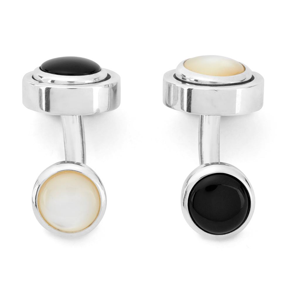 Turnbull & Asser’s Reversible Monochrome Sterling Silver Round Cufflinks feature elegant edges with one white mother-of-pearl center and the other a black onyx center, shown on a plain light gray background.