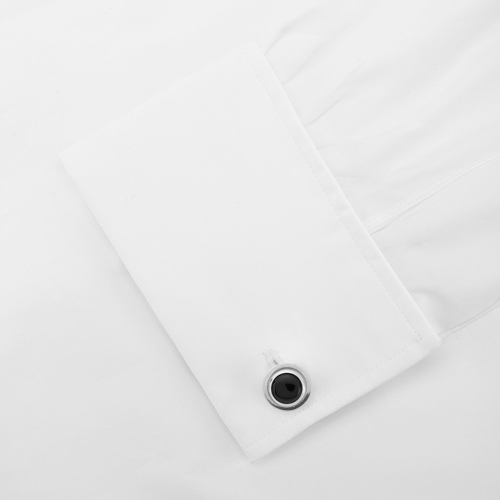 View 4 of product Turnbull & Asser’s Reversible Monochrome Sterling Silver Round Cufflinks feature elegant edges with one white mother-of-pearl center and the other a black onyx center, shown on a plain light gray background.