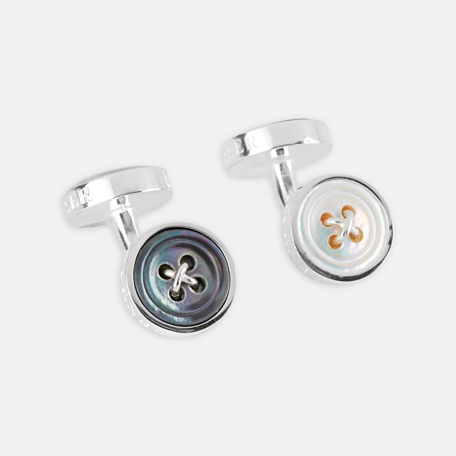 View 1 of product Turnbull & Asser’s Reversible Sterling Silver Mother-of-Pearl Button Cufflinks feature a round button design with four central holes, showcasing a dark iridescent face on one side and a light mother-of-pearl face on the other.