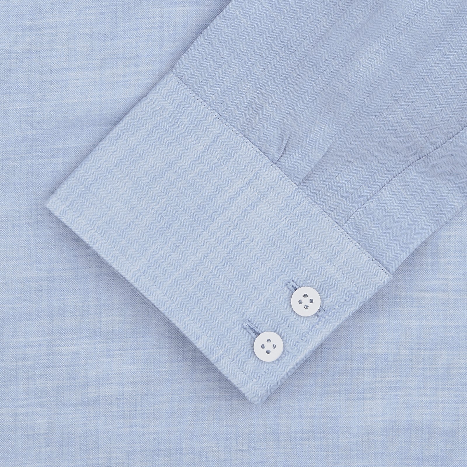 View 3 of product The Turnbull & Asser Esquire Edit Tailored Fit Light Blue Shirt features a Kent collar and 2-button cuffs, neatly folded and displayed on a plain light gray background.