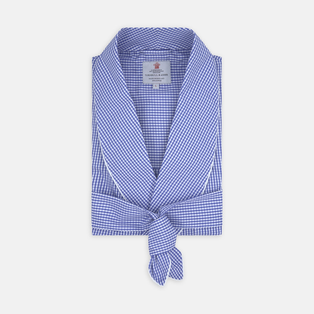 The Turnbull & Asser Mid Blue Gingham Check Piped Cotton Gown, featuring a shawl collar and tied belt, is elegantly displayed against a white background.