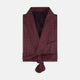 The Turnbull & Asser Burgundy Piped Silk Spot Gown features small white polka dots, a shawl collar, fabric belt, and chest pocket—luxurious nightwear and a stylish men’s statement piece—shown on a white background.