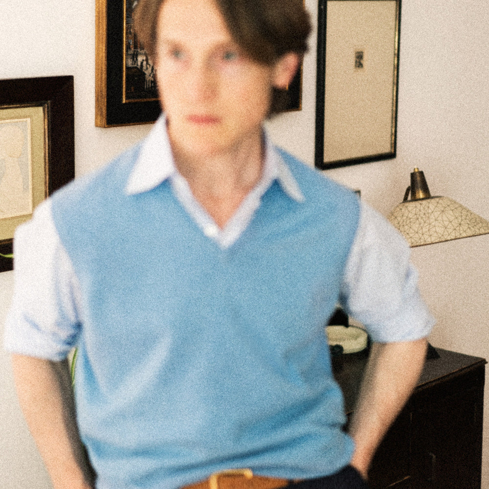 The Sky Blue Fine Cashmere Slipover by Turnbull & Asser is laid flat on a white background, showcasing its lightweight design and ribbed neckline, armholes, and hem for a refined finish.