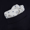 View 4 of product The White and Navy Spot Silk Pocket Square by Turnbull & Asser features evenly spaced blue dots and the brand's logo in blue on the bottom right, with a folded corner highlighting this classic men's accessory.