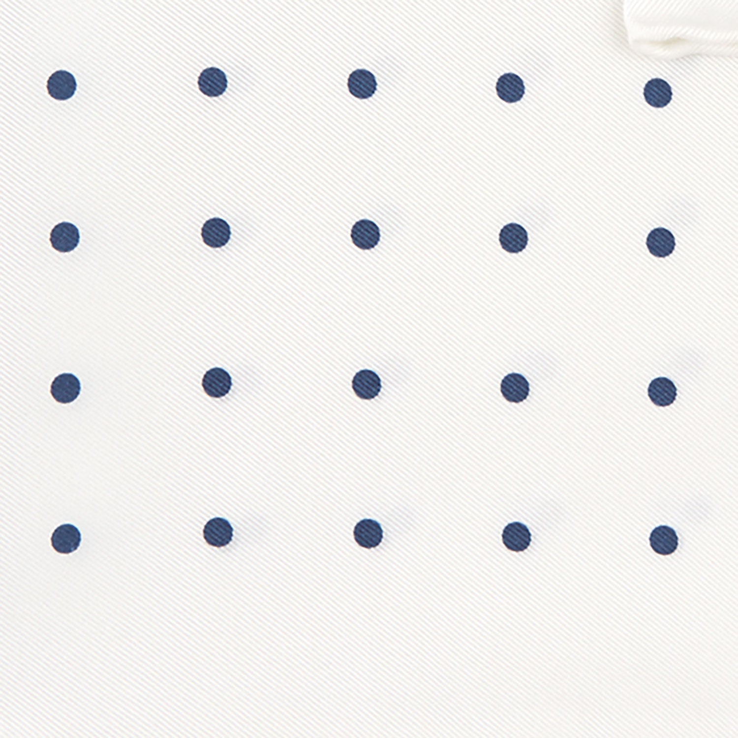 View 3 of product The White and Navy Spot Silk Pocket Square by Turnbull & Asser features evenly spaced blue dots and the brand's logo in blue on the bottom right, with a folded corner highlighting this classic men's accessory.