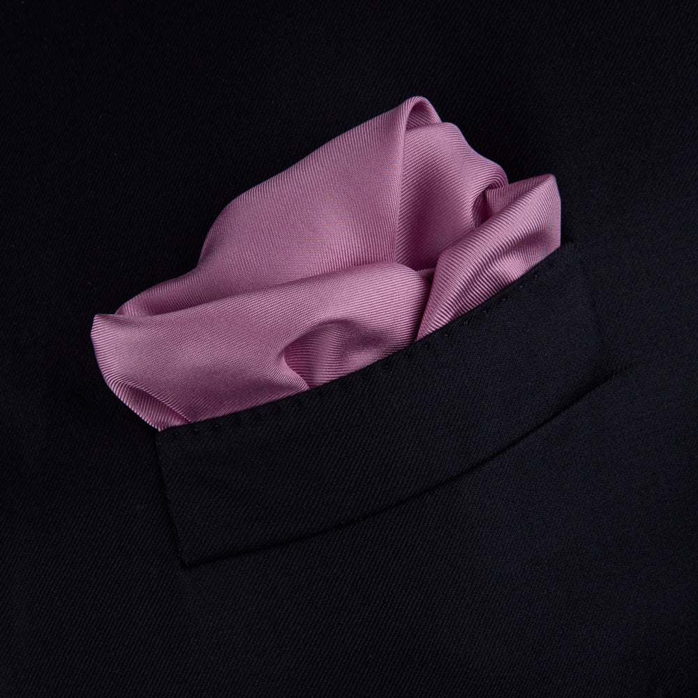 The Lilac and White Piped Silk Pocket Square by Turnbull & Asser features a smooth lilac silk fabric with a refined white piped edge and the brand's signature printed in white on the lower right corner.