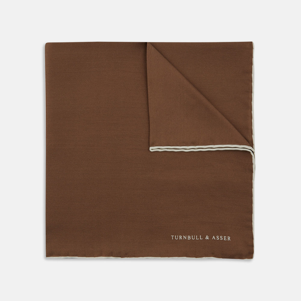 The Brown and White Piped Silk Pocket Square by Turnbull & Asser features a stitched edge and discreet branding—an elegant accessory for any occasion.
