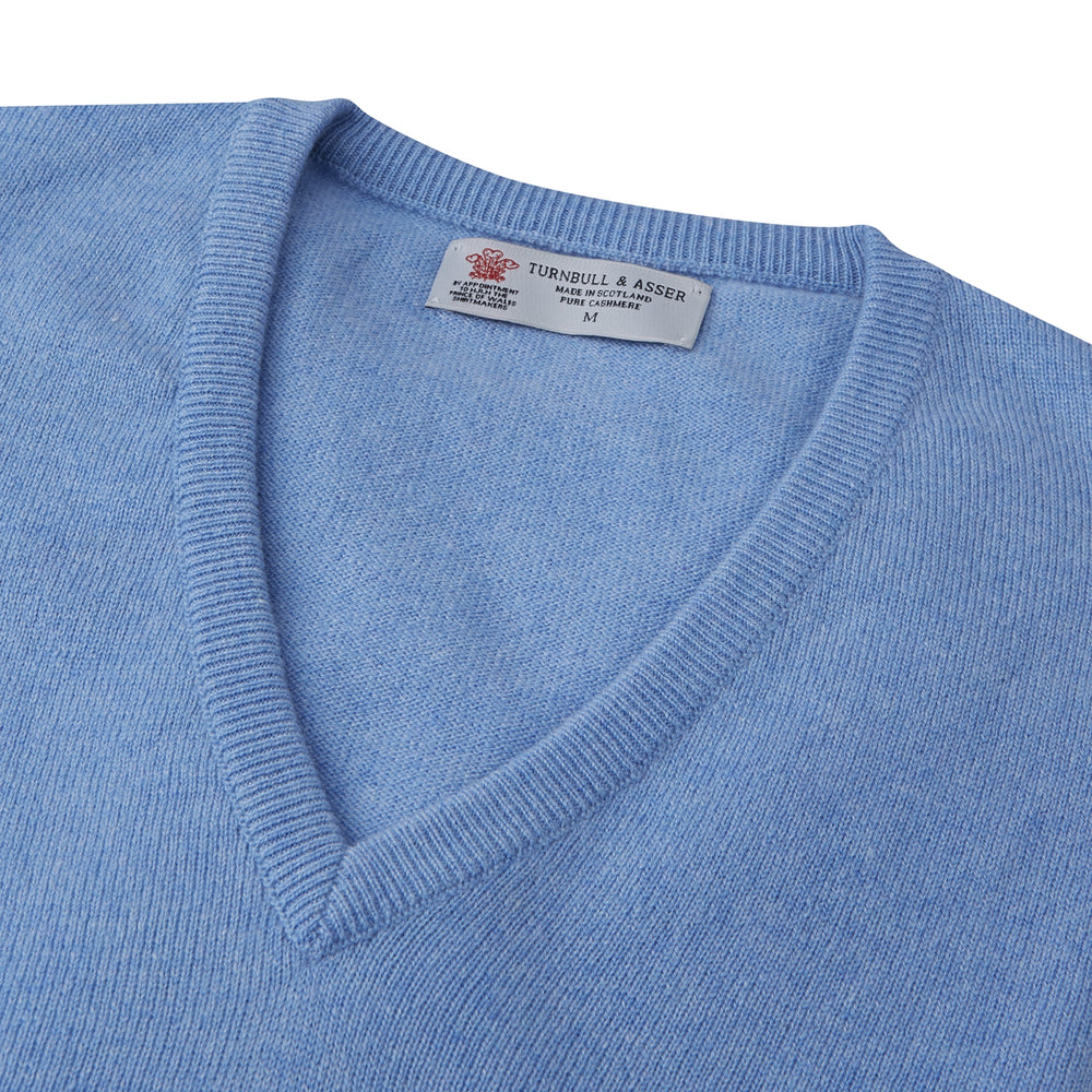 A Sky Blue Fine Cashmere V-Neck Jumper by Turnbull & Asser, neatly folded with visible ribbed collar and cuff, is displayed on a white background. The label appears inside the collar.