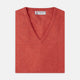 A folded Crimson Fine Cashmere Slipover by Turnbull & Asser in coral-red is shown against a white background, with the visible neckline label highlighting its premium Scottish cashmere quality.