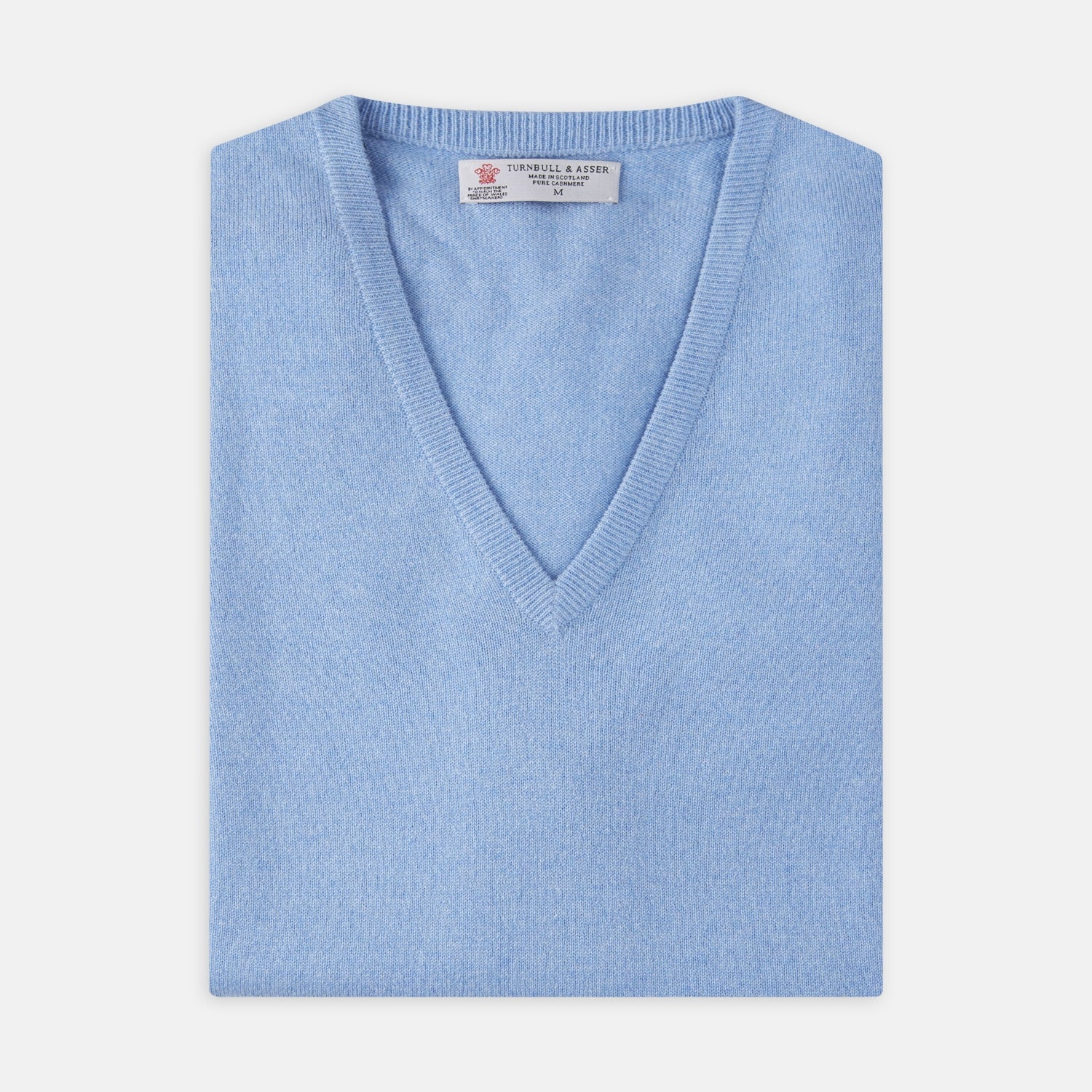 View 4 of product The Sky Blue Fine Cashmere Slipover by Turnbull & Asser is laid flat on a white background, showcasing its lightweight design and ribbed neckline, armholes, and hem for a refined finish.