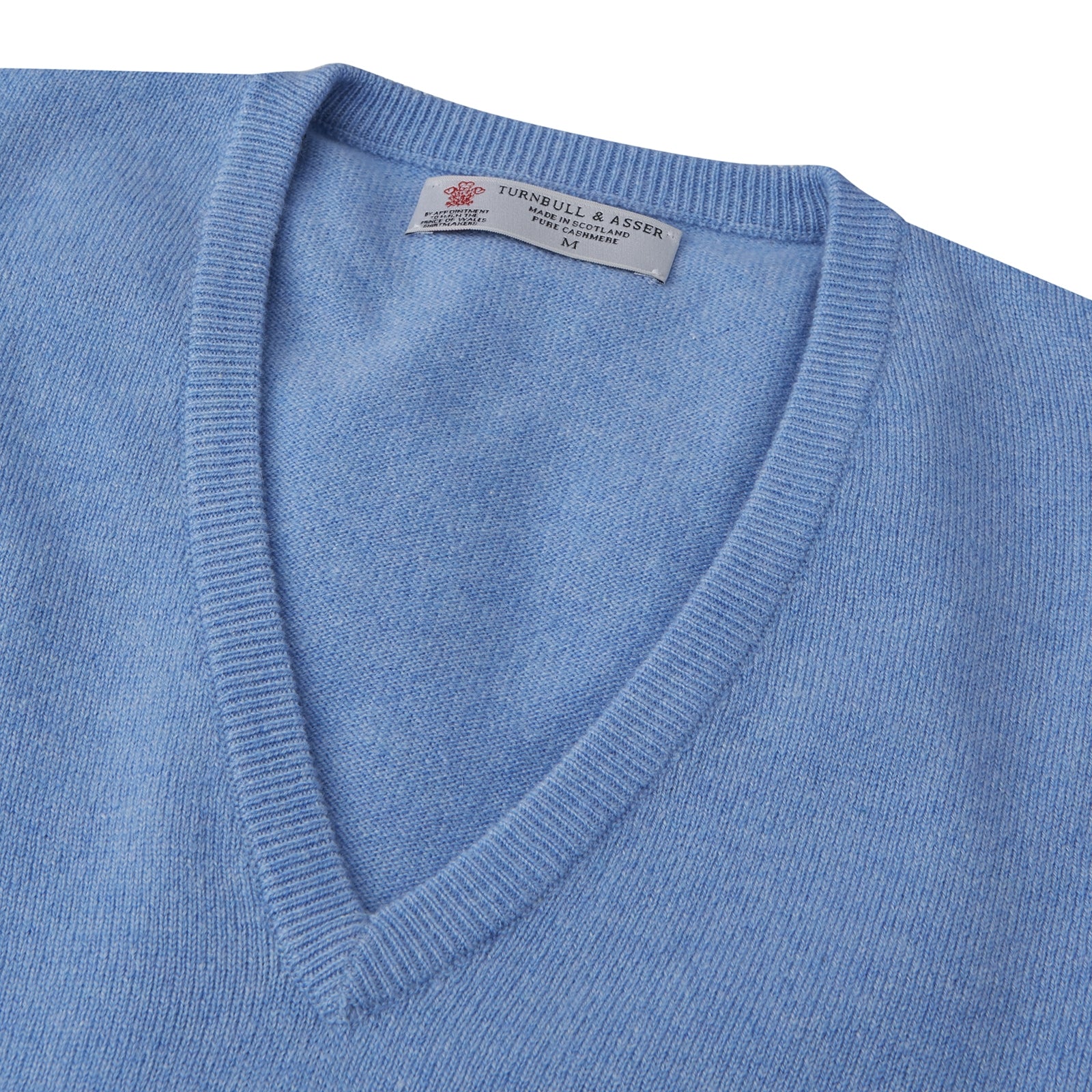 View 3 of product The Sky Blue Fine Cashmere Slipover by Turnbull & Asser is laid flat on a white background, showcasing its lightweight design and ribbed neckline, armholes, and hem for a refined finish.