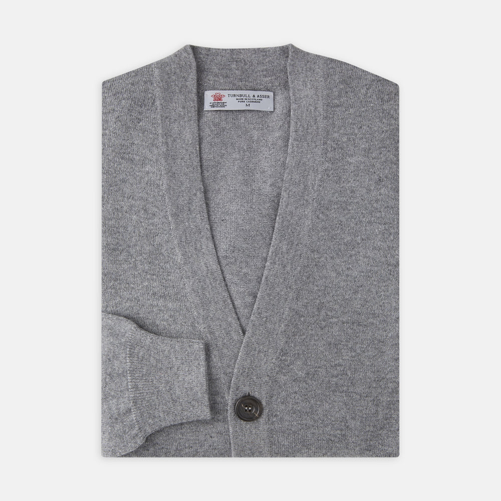 The Grey Fine Cashmere Cardigan by Turnbull & Asser is a long-sleeve, button-up sweater with two front pockets, shown on a white background.