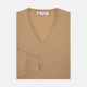 The Turnbull & Asser Camel V-Neck Merino Wool Jumper, with ribbed cuffs and a visible white neckline label, is neatly folded with one sleeve showing—an essential, versatile staple for any gentleman's wardrobe.
