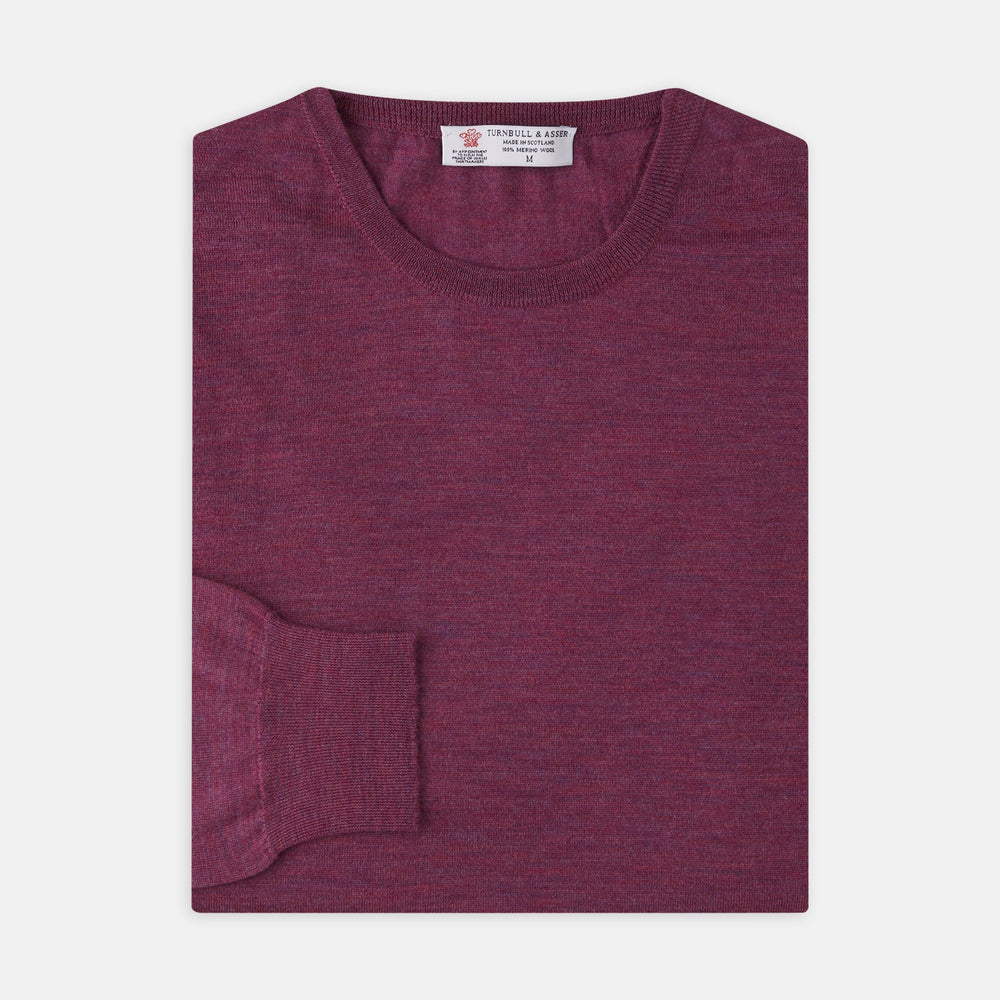 The Plum Fine Merino Crew Neck Jumper by Turnbull & Asser features classic Scottish knitwear craftsmanship in a rich maroon shade, shown neatly folded with long sleeves against a plain white background.