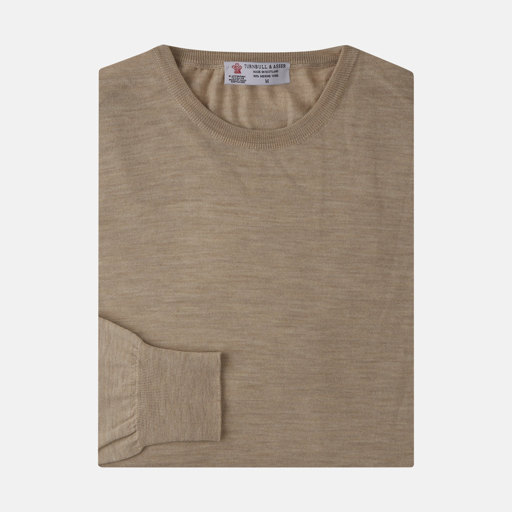 The Camel Fine Merino Crewneck Jumper by Turnbull & Asser is a light brown Scottish knitwear piece with a ribbed collar and cuffs, neatly displayed on a plain white background.