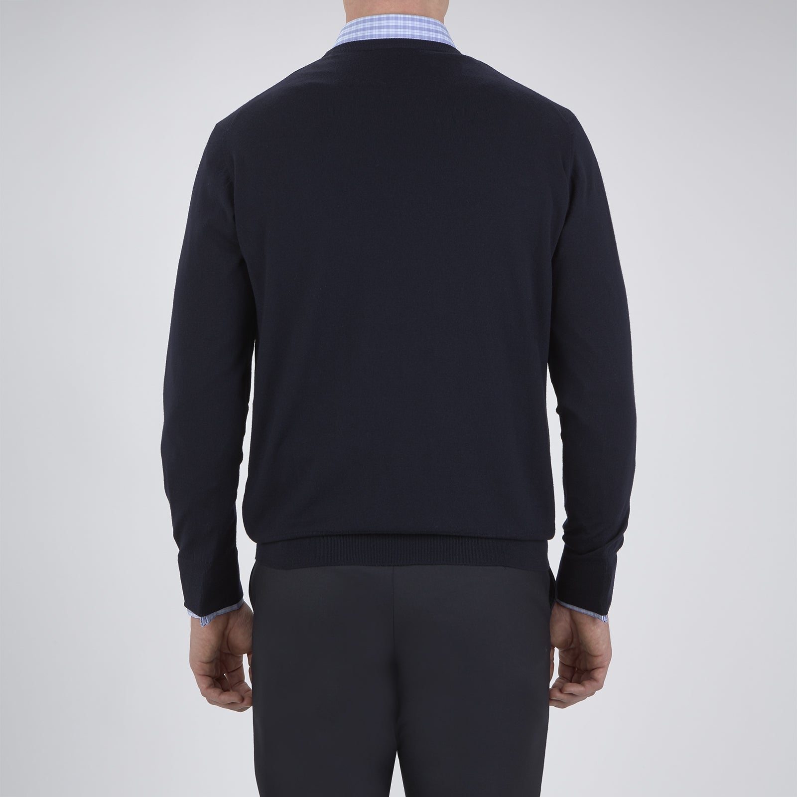 View 3 of product A neatly folded Indigo Crew Neck Merino Wool Jumper by Turnbull & Asser, featuring a visible brand label at the collar and one sleeve tucked across the front, displayed on a white background—a versatile staple for any gentleman's wardrobe.