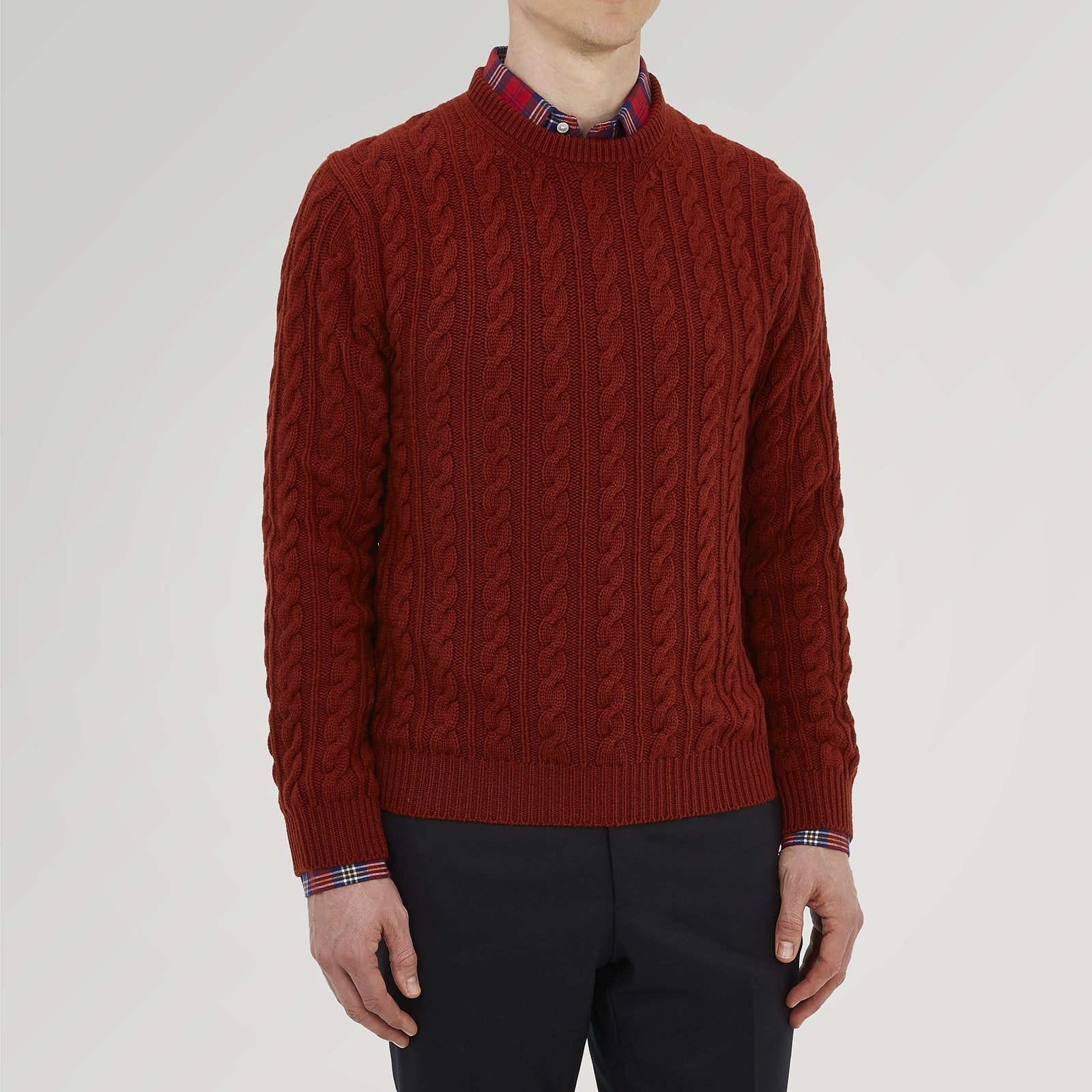 View 2 of product The Harissa Crew Neck Cable Knit Cashmere Jumper by Turnbull & Asser features a chunky, folded cable knit in deep harissa, with ribbed crew neckline and cuffs, and a signature label on the inside collar.
