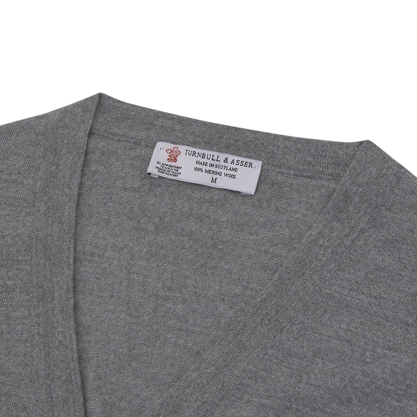 View 2 of product The Flannel Grey Merino Wool Cardigan by Turnbull & Asser features a light grey flannel finish, V-neck, ribbed cuffs, and button-up front—crafted for timeless style and comfort.