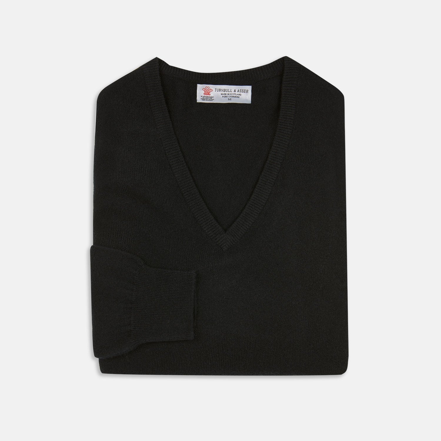 View 1 of product The Turnbull & Asser Black V-Neck Cashmere Jumper is neatly folded, crafted from luxury Scottish cashmere, and features a visible brand label inside the collar, displayed on a plain white background.