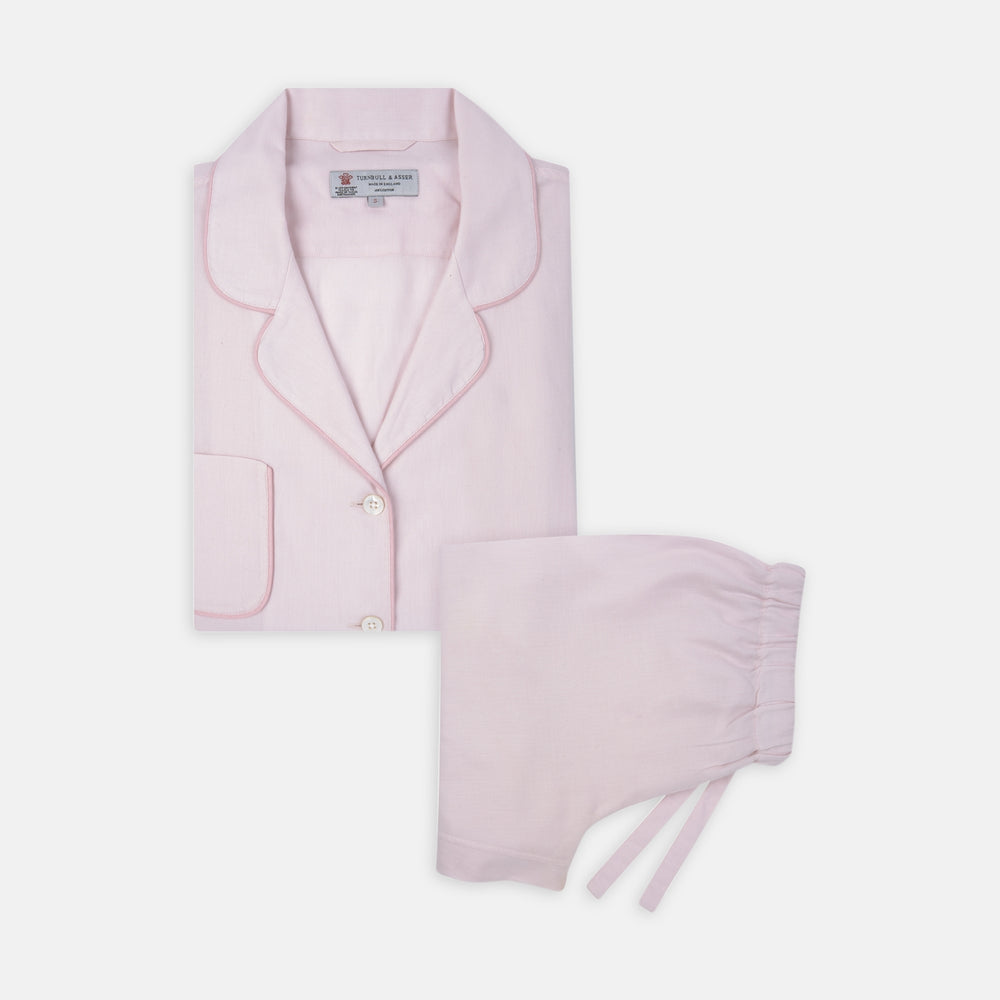 The Turnbull & Asser Ladies' Pink Cotton-Cashmere Pyjama Set features a collared, button-up top with a pocket and matching drawstring pants, both detailed with subtle piping, displayed on a plain white background.