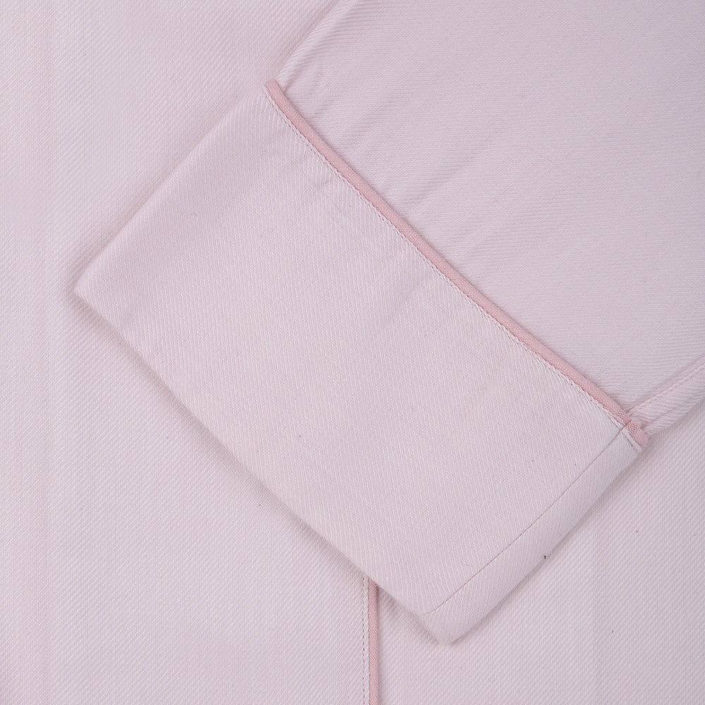 The Turnbull & Asser Ladies' Pink Cotton-Cashmere Pyjama Set features a collared, button-up top with a pocket and matching drawstring pants, both detailed with subtle piping, displayed on a plain white background.