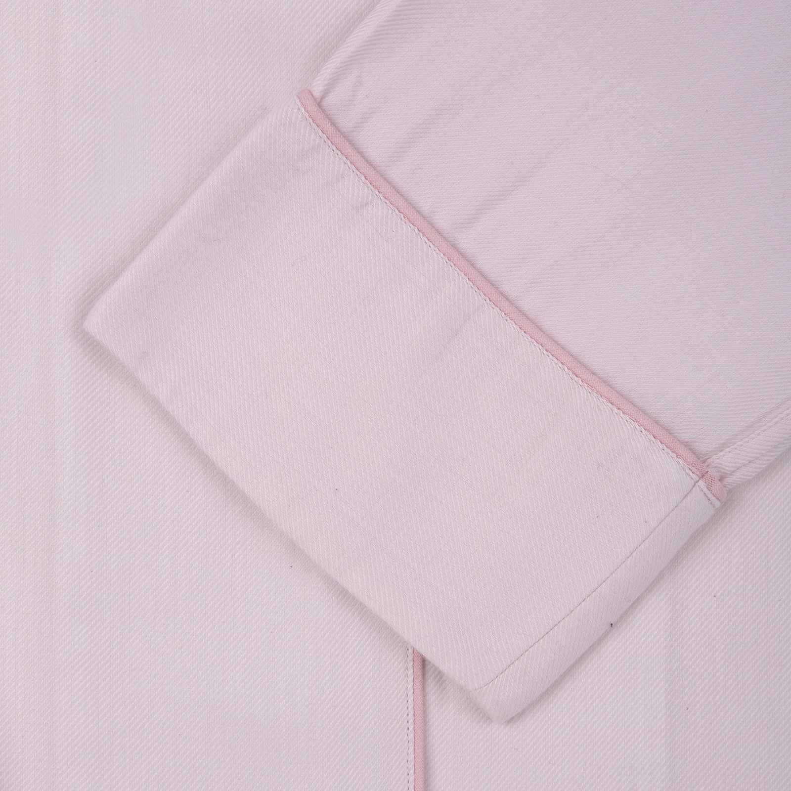 View 2 of product The Turnbull & Asser Ladies' Pink Cotton-Cashmere Pyjama Set features a collared, button-up top with a pocket and matching drawstring pants, both detailed with subtle piping, displayed on a plain white background.
