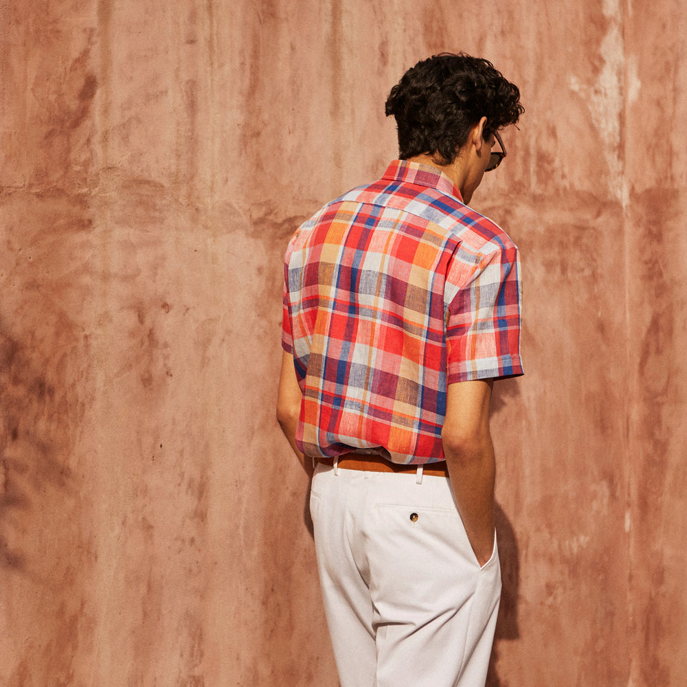 The Turnbull & Asser Red Madras Check Weekend Fit Short Sleeve Linen Shirt features a Dorset collar, white buttons, and a red, blue, white, and beige plaid pattern. Shown on a plain white background.