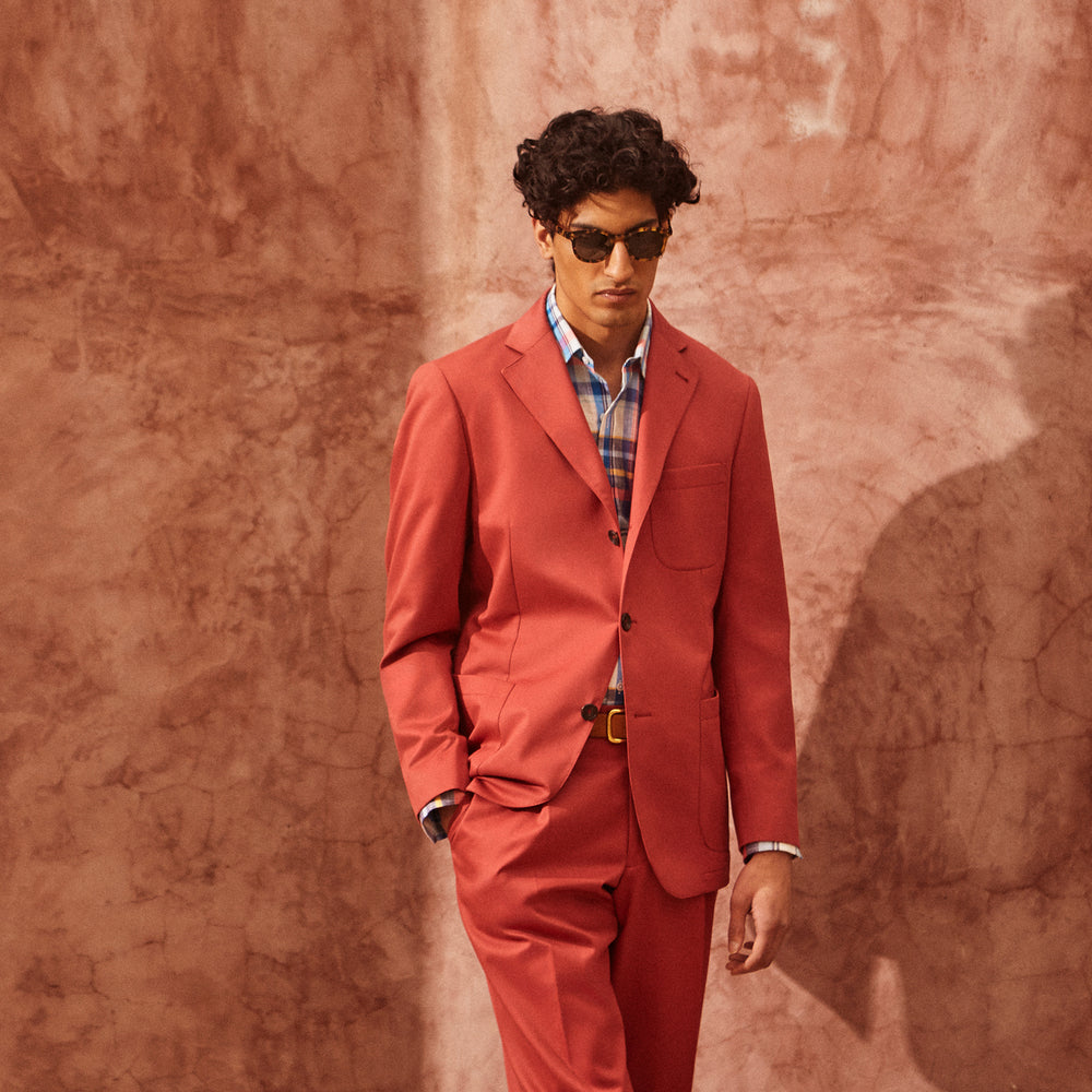 Turnbull & Asser Clay Red Cotton Twill Pleated Trousers feature a tailored fit, side pockets, and front button closure. Made in Italy, they're ideal for smart casual looks and are showcased against a plain white background.