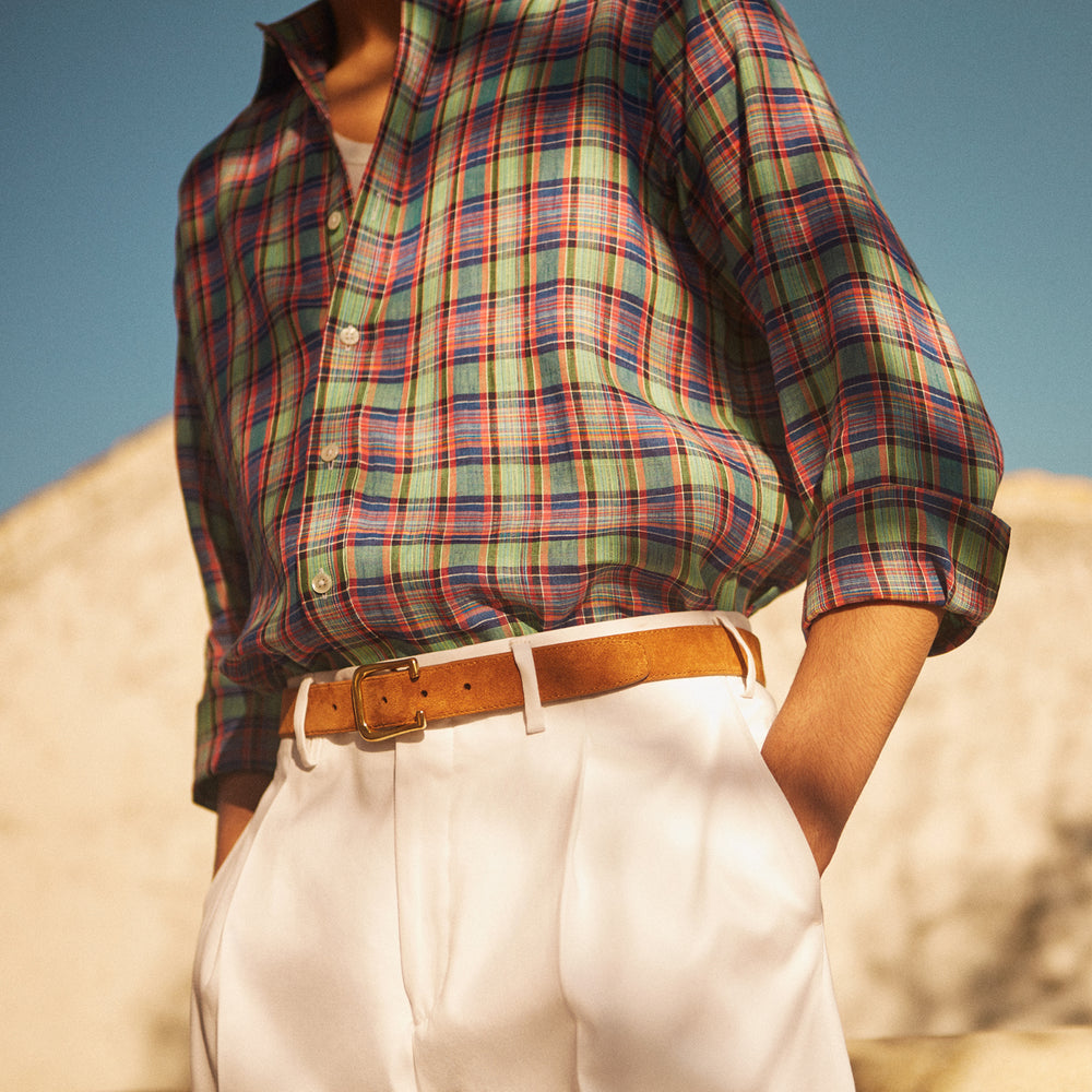 Turnbull & Asser’s White Cotton Pleated Trousers, a summer classic, are elegantly displayed against a crisp white backdrop.